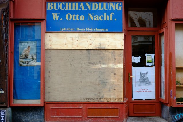 "Wir haben geöffnet" steht auf dem Brett, das die zerstörte Scheibe der Buchhandlung ersetzt.